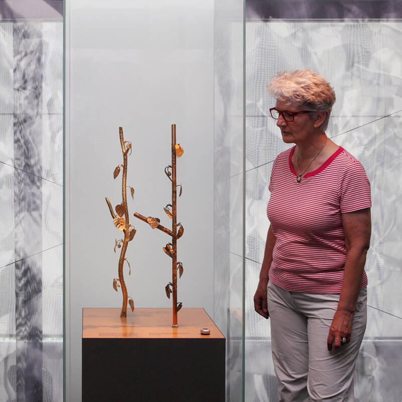 Besucherin vor der Vitrine zum rätselhaften Kultbäumchen aus der Keltenstadt von Manching.