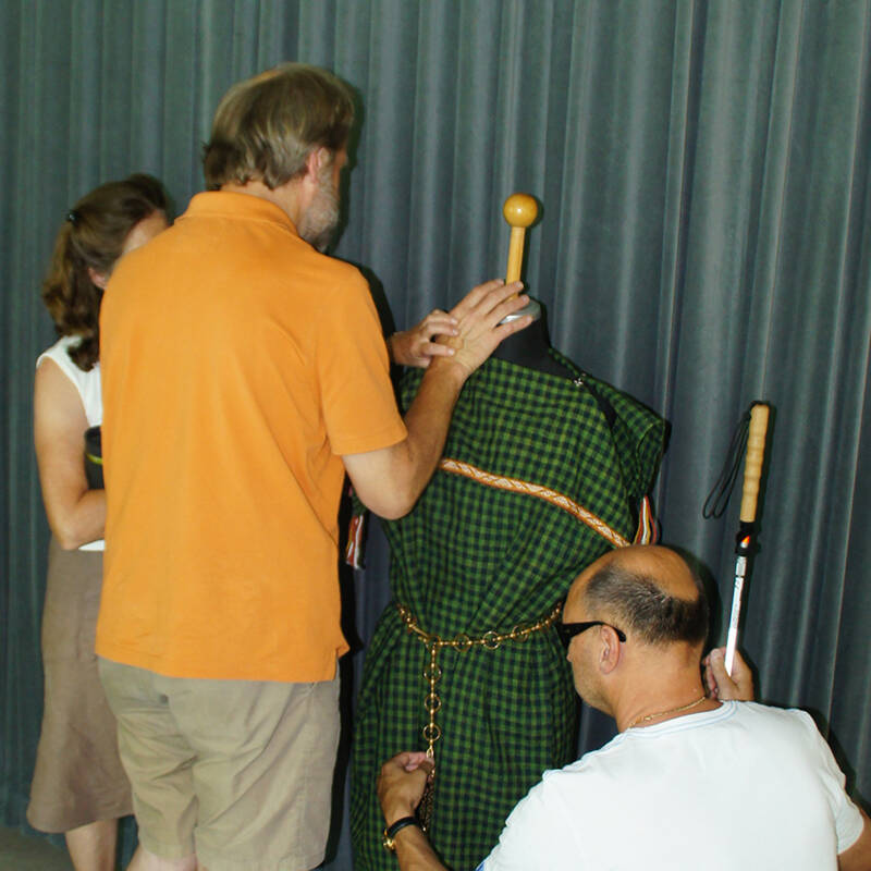 Zwei blinde Besucher ertasten Repliken keltische Trachtelemente.