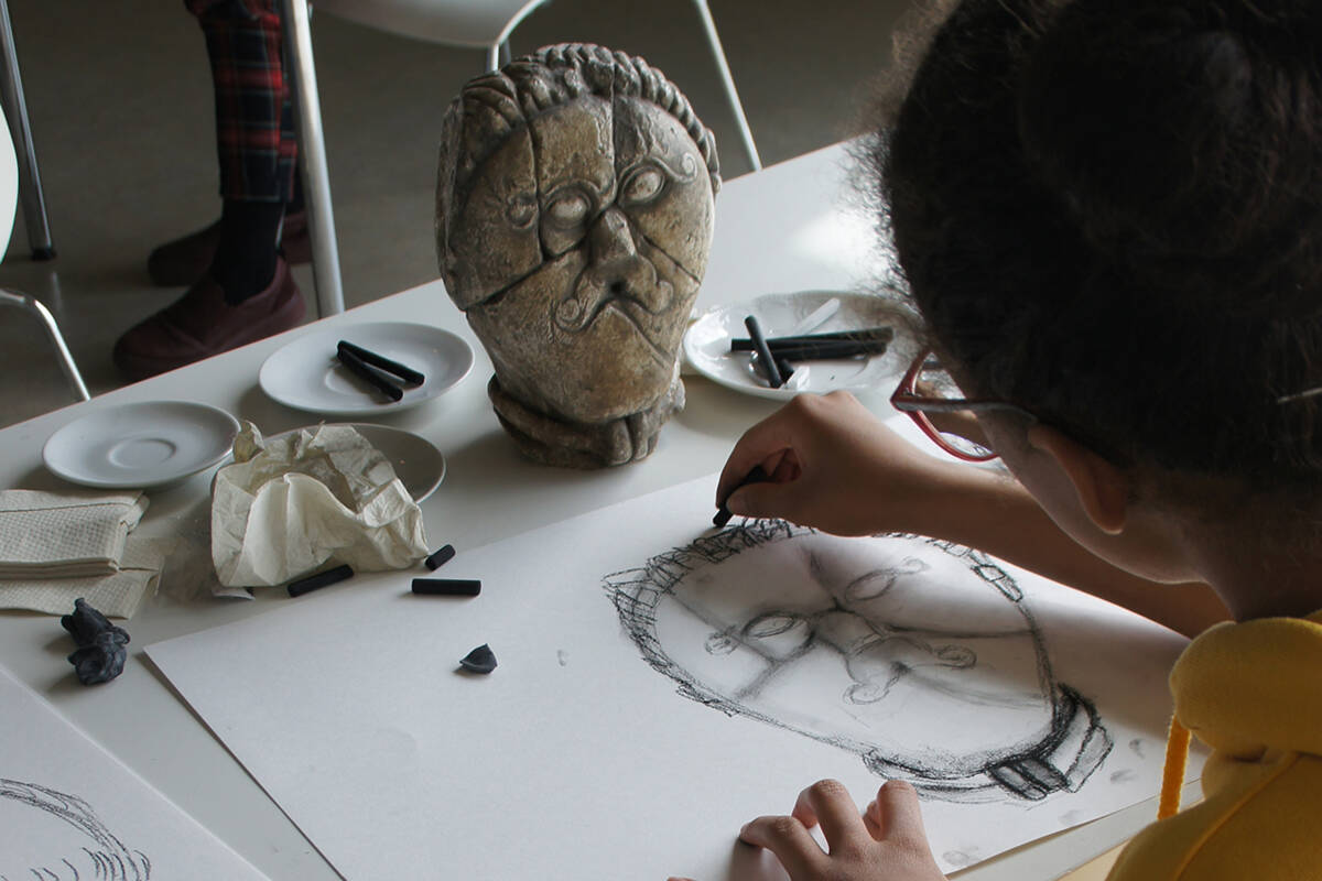 Eine Schülerin widmet sich dem keltischen Steinkopf von Mšecké Žehrovice.