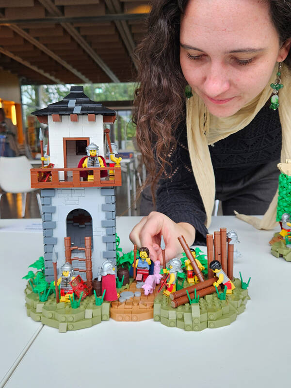 Museumsmitarbeiterin Jasmin Braun begutachtet das Lego-Modell eines Limesturms.