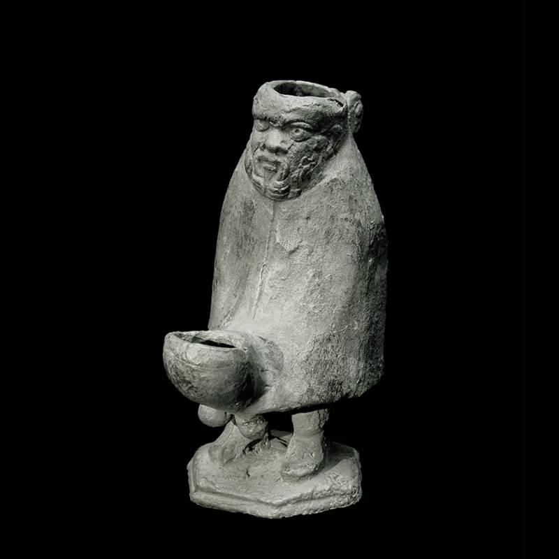 Römische Bronzelampe mit grotesker Darstellung eines Mannes.