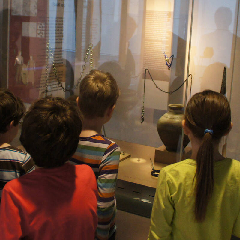 Kinder bestaunen archäologische Funde aus der Keltenstadt von Manching.