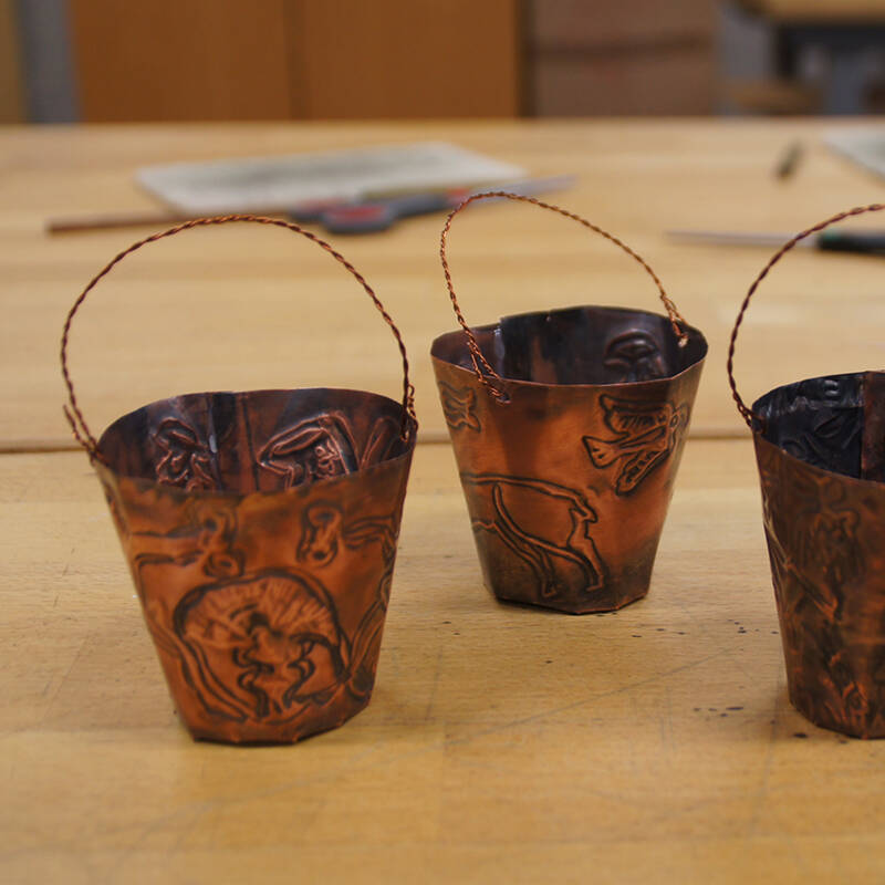 Die Windlichter aus Kupferblech erinnern an Trinkbehälter, sogenannte Situlen.