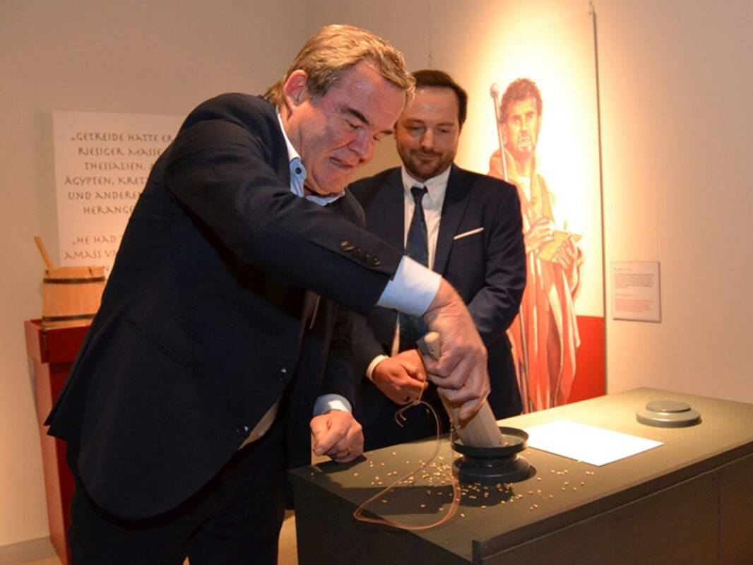 Albert Gürtner und Museumsmitarbeiter Markus Strathaus an einer Mitmachstation zur Getreidezuweisung.